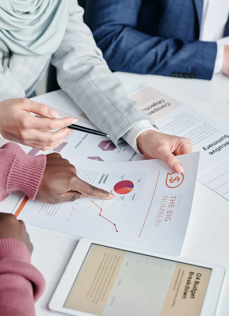 Hands pointing at charts and documents on a work table